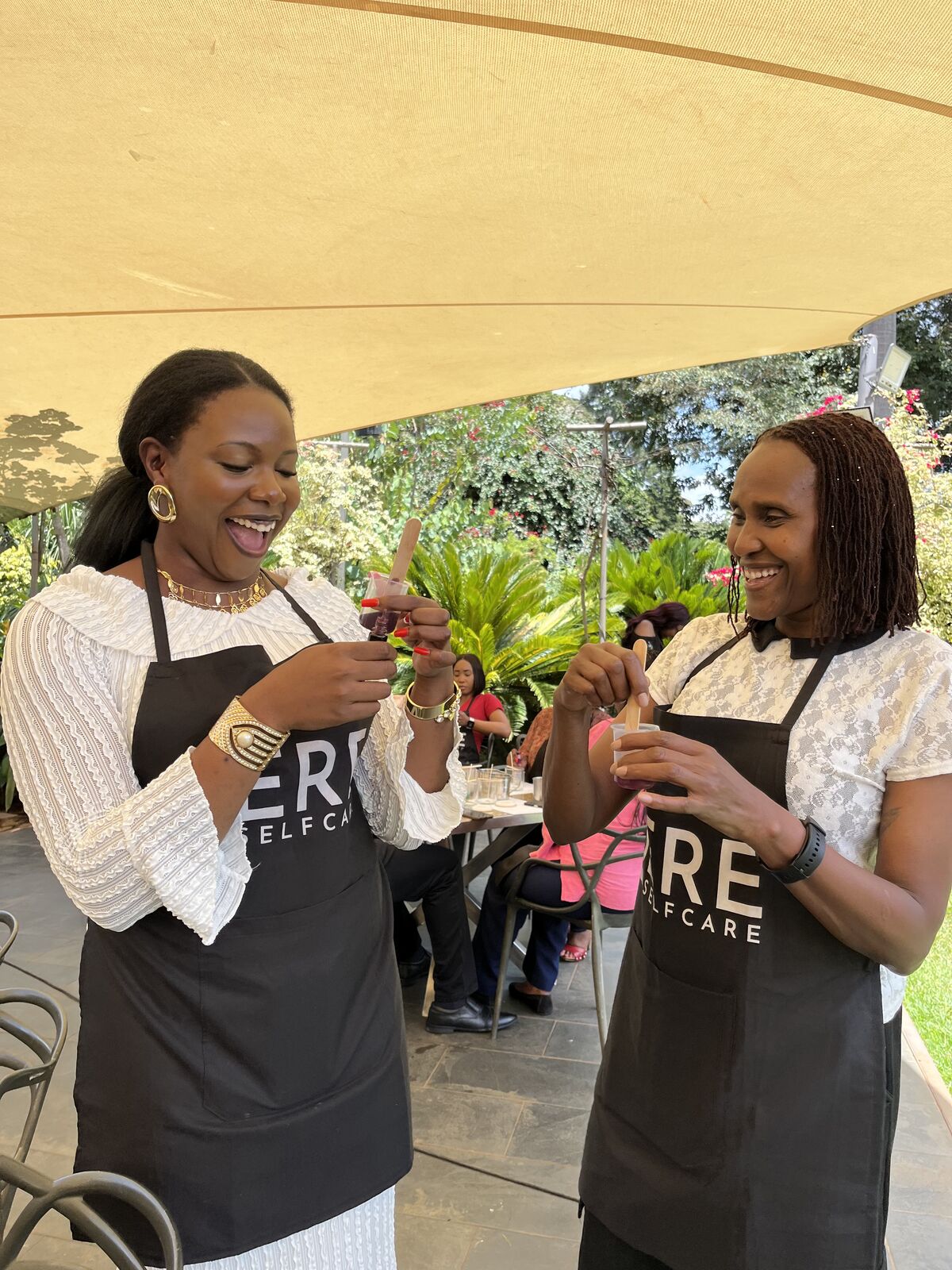 Two guests in Sere aprons laughing together