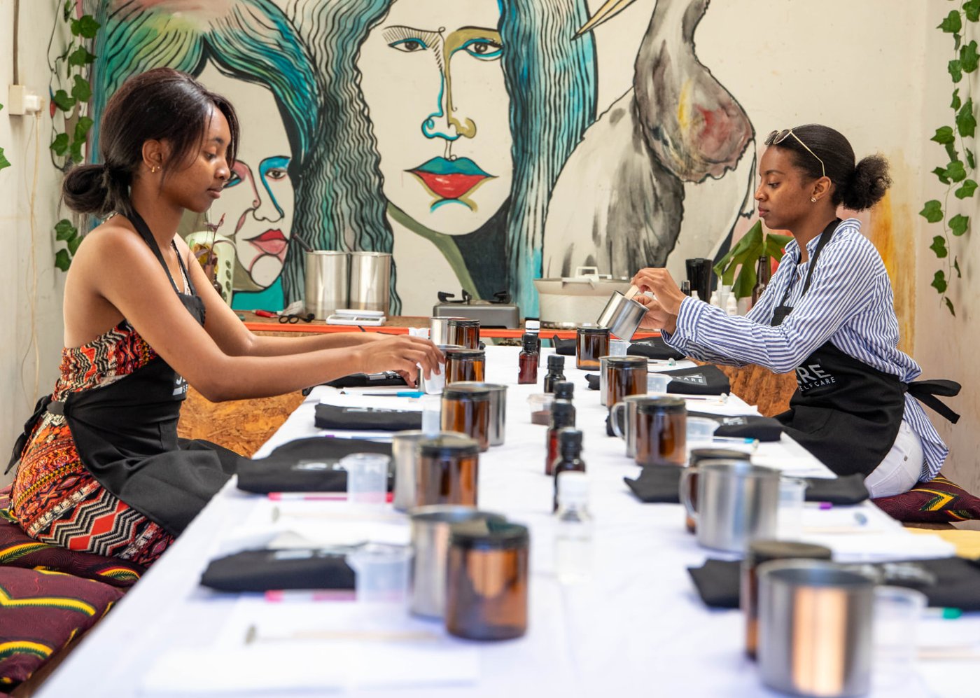 Two women making candles together at a Sere workshop table